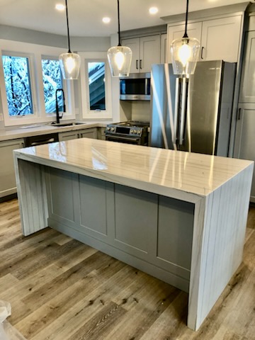 Gray kitchen island with quartz countertop by Oakridge Cabinet and Design