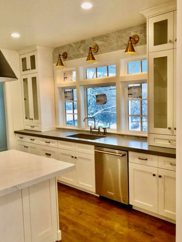 White kitchen cabinets with gold sconces by Oakridge Cabinet and Design
