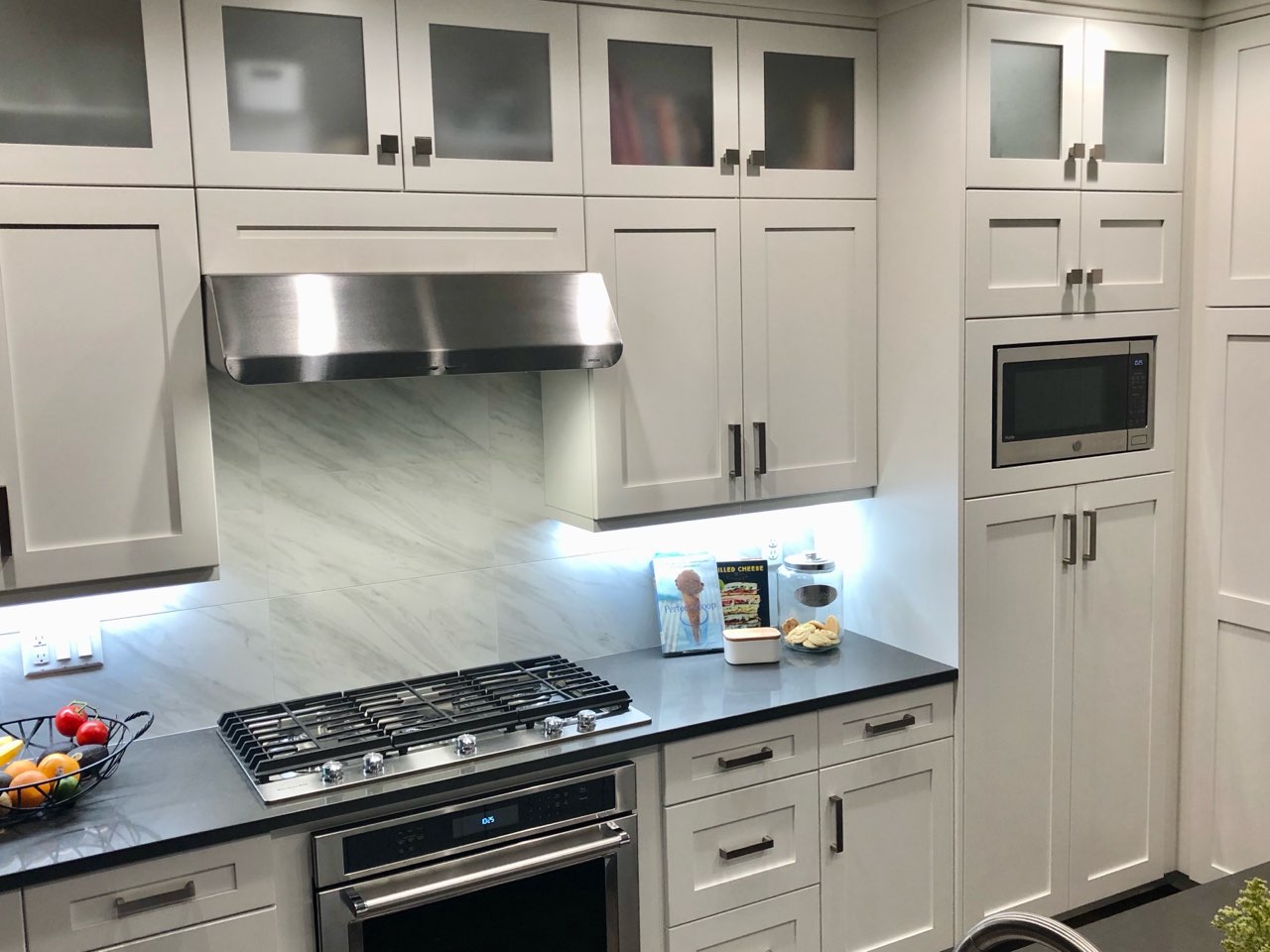 White kitchen with marble backsplash by Oakridge Cabinet and Design